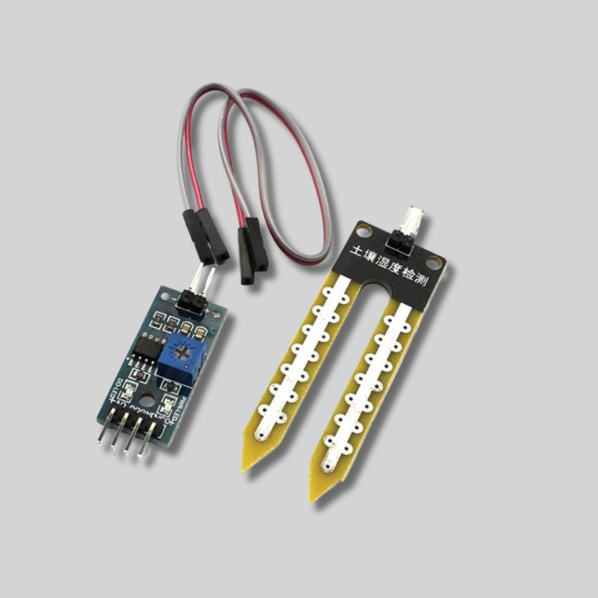 The complete soil moisture sensor module kit, including the fork-shaped probe, the control board, and jumper cables for Arduino.